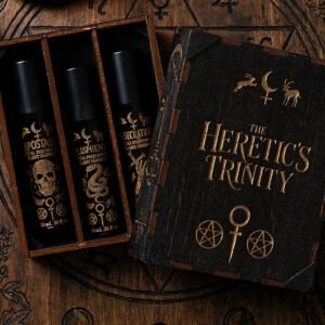 The Heretic's Trinity Perfume Oil Set on an antique carved wood table.